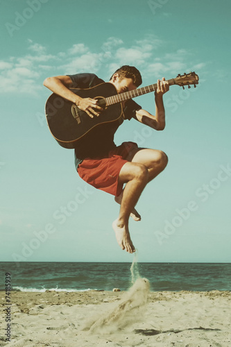 Boy playing guitar on the beach