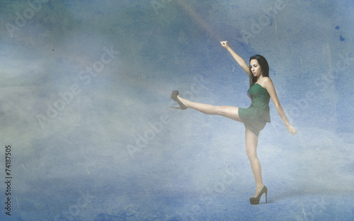 girl in green dress kicking empty space