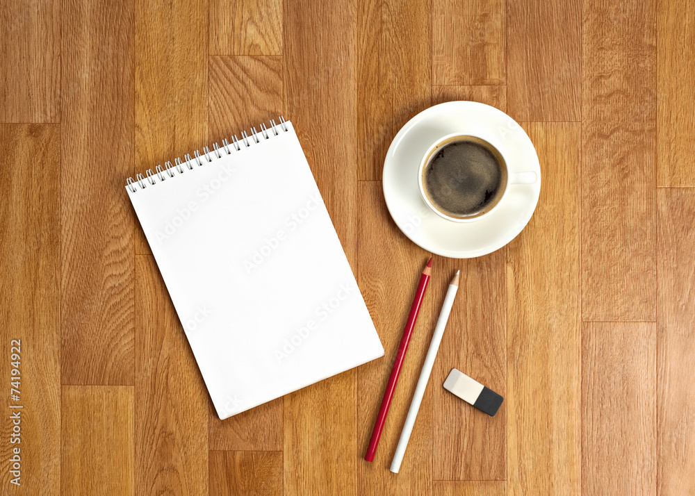 Blank notepad with office supplies and cup of coffee on wooden t Blank notepad with office supplies and cup of coffee on wooden t