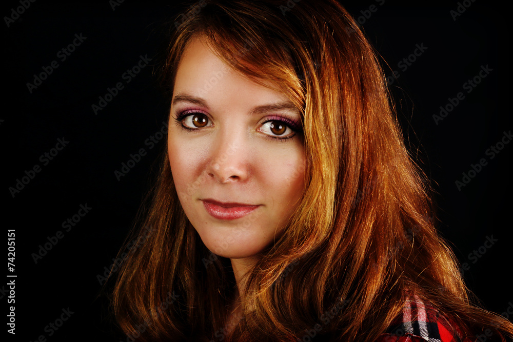 Fototapeta premium portrait of a young redhead girl on a black background