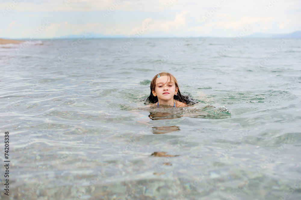 Portrait of preteen girl swimming in sea