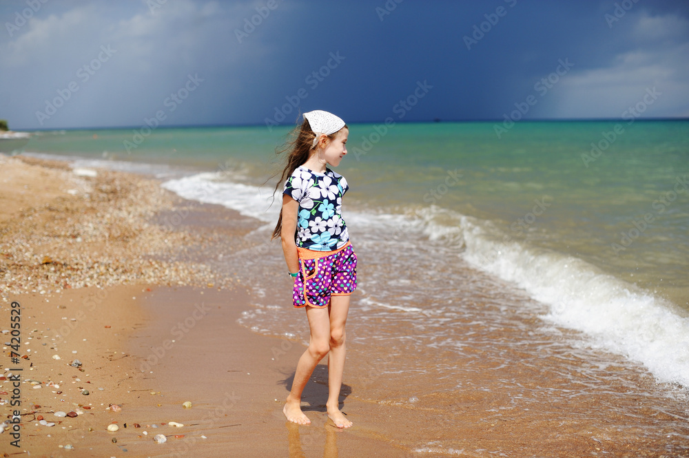 Adorable happy little girl on beach vacation