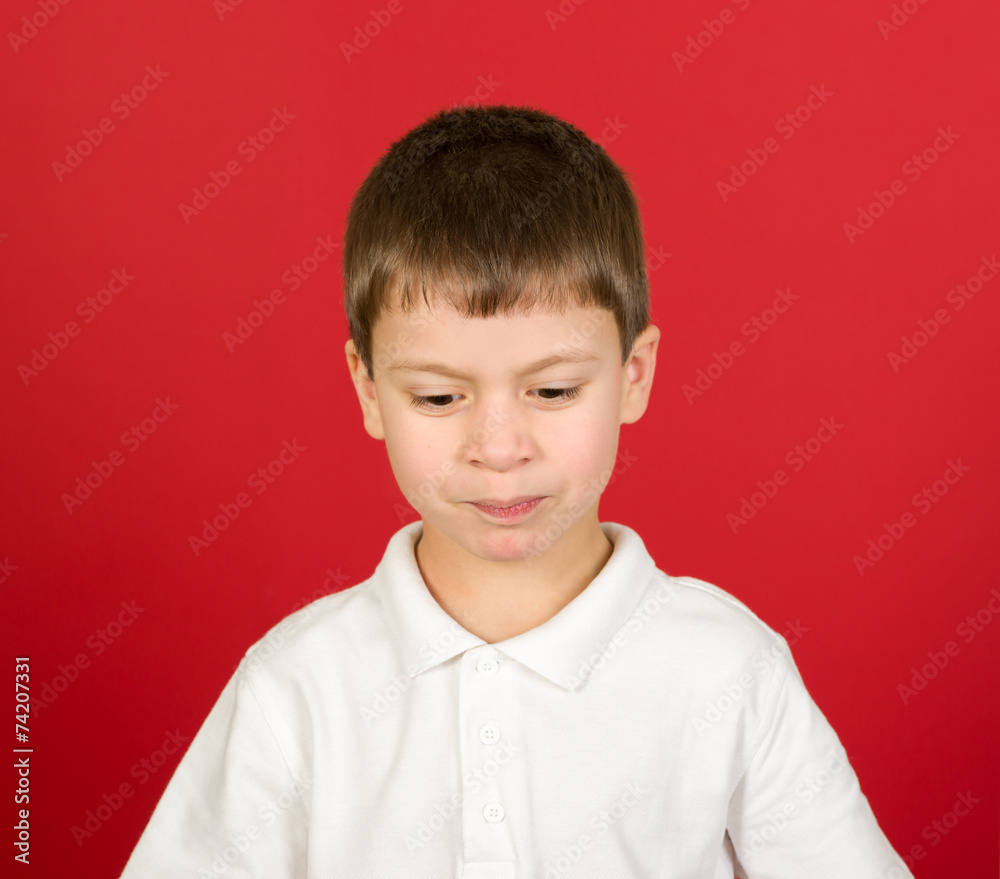 grimacing boy portrait on red grimacing boy portrait on red