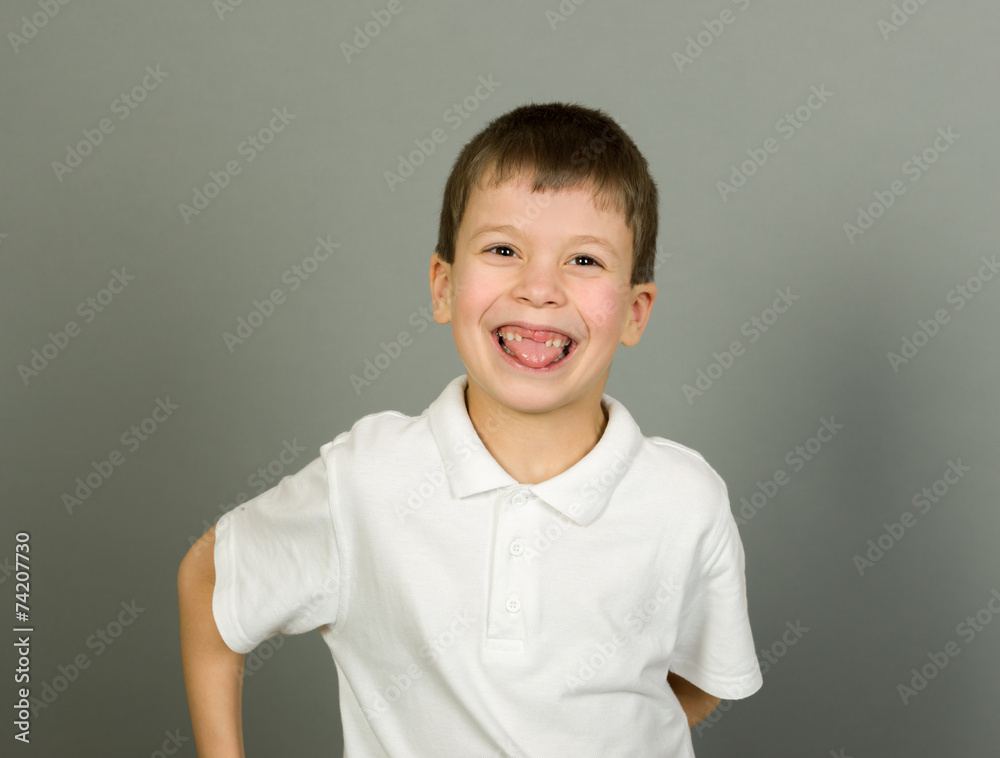 grimacing boy portrait on grey grimacing boy portrait on grey