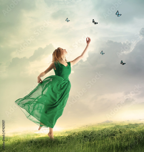 Beautiful girl catching butterflies on a mountain photo