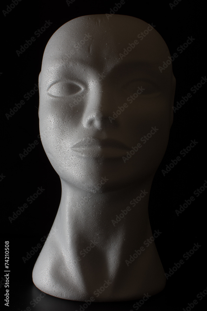 Mannequin head isolated on a black background with side lighting Mannequin head isolated on a black background with side lighting
