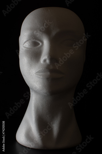 Mannequin head isolated on a black background with side lighting