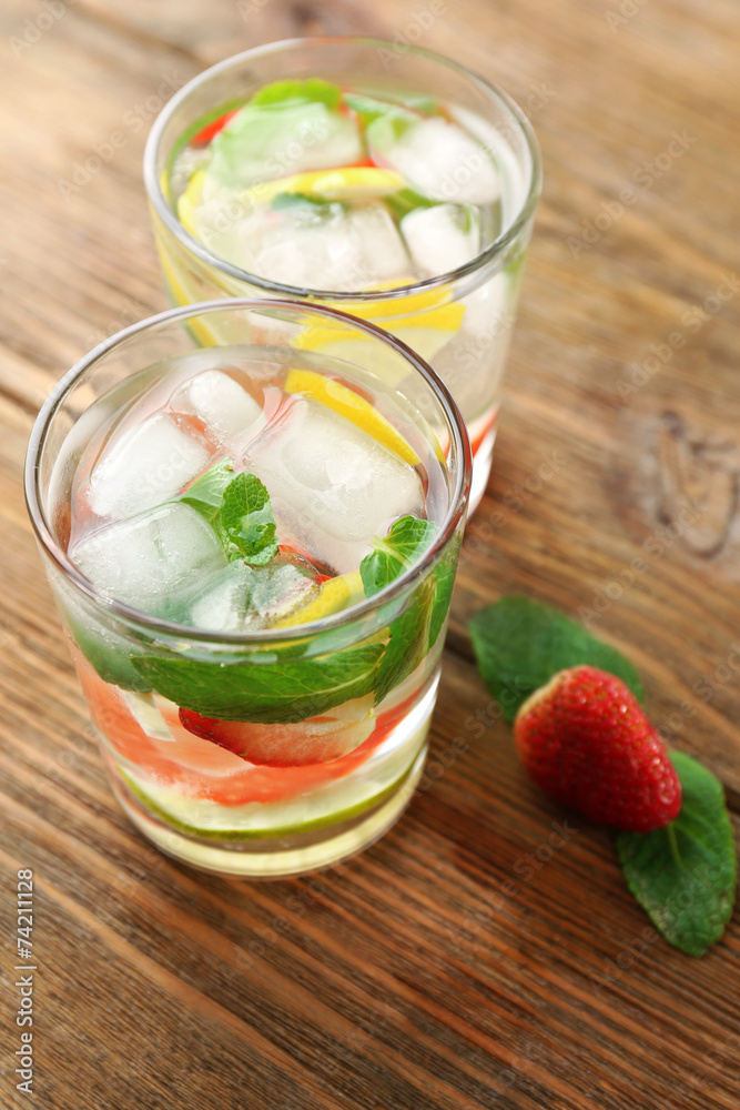 Summer cocktail with ice cubes on wooden table Summer cocktail with ice cubes on wooden table