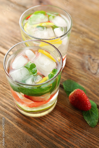 Summer cocktail with ice cubes on wooden table