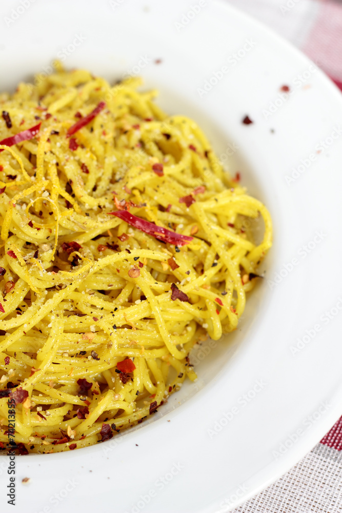 Spaghetti with pesto, chili flakes and chili on a white plate. Spaghetti with pesto, chili flakes and chili on a white plate.