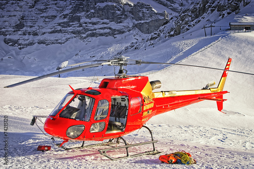 Red helicopter landed at swiss ski resort near Jungfrau mountain photo