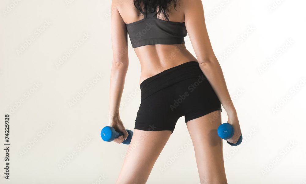 Close up of young woman exercising with dumbbells Close up of young woman exercising with dumbbells