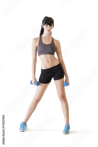 Young attractive girl exercising with pair of dumbbells
