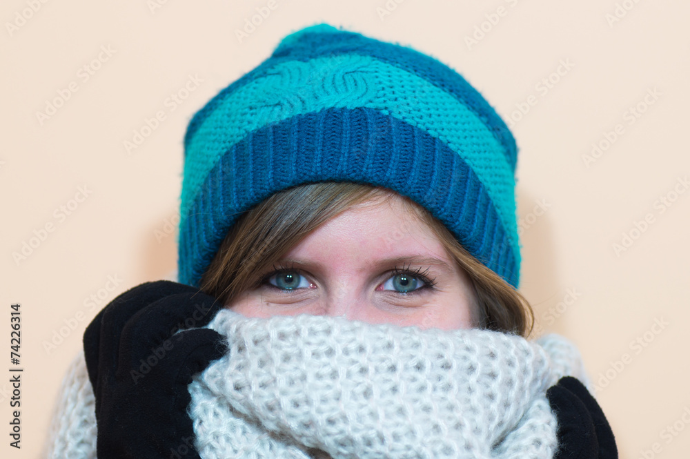 Girl wearing black gloves blue beanie and a fluffy scarf