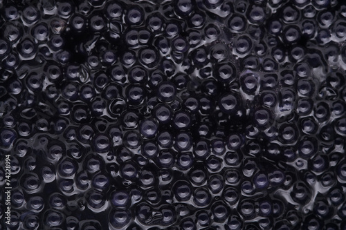 Black caviar background, top view