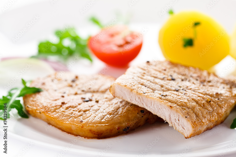 Fried steaks, boiled potatoes and vegetable salad Fried steaks, boiled potatoes and vegetable salad