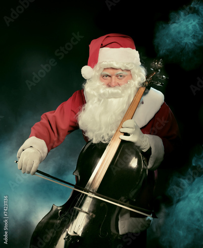 Картината върху платно Santa Cklaus playing cello over dark background