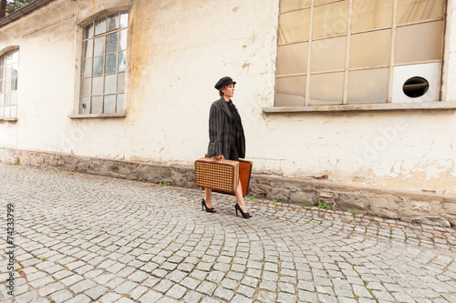 Canvas Print Woman walking on the street porphyry with suitcases