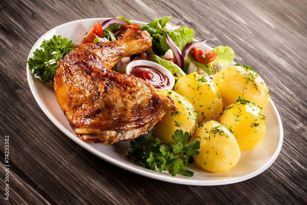 Barbecued chicken leg with boiled potatoes and vegetables Barbecued chicken leg with boiled potatoes and vegetables