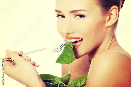 Woman eating lettuce from a bowl wit