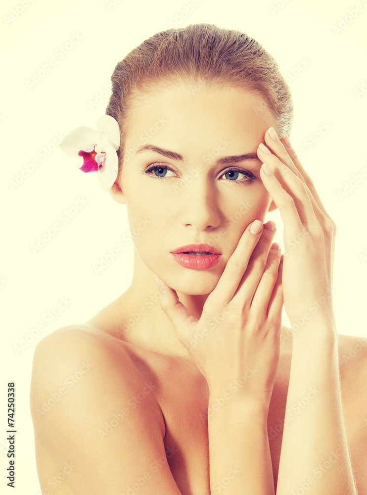 Fototapeta premium Portrait of beautiful caucasian woman with orchid flower.