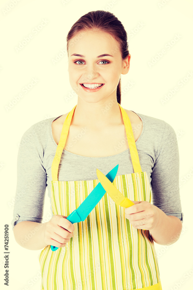 Attractive woman in kitchen apron with knives. Attractive woman in kitchen apron with knives.