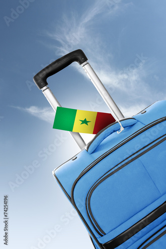 Destination Senegal. Blue suitcase with flag.