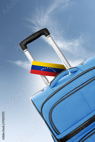 Destination Venezuela. Blue suitcase with flag.
