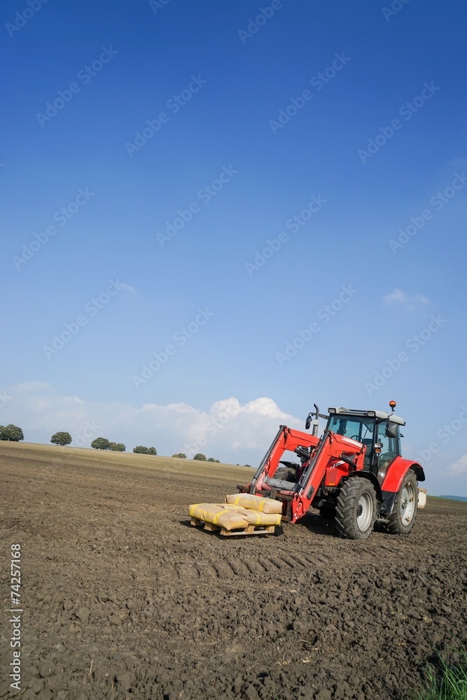 Ackerbau, Traktor mit Saatgetreide in Säcken auf einem Feld Ackerbau, Traktor mit Saatgetreide in Säcken auf einem Feld