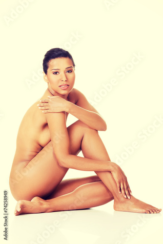 Sexy fit naked woman with healthy clean skin sitting