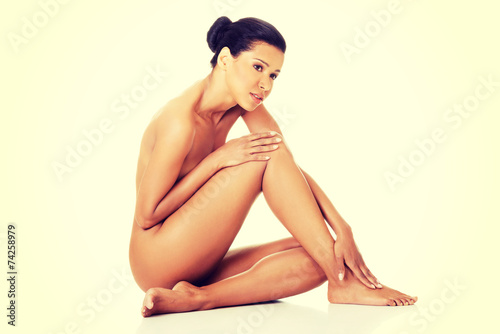 Sexy fit naked woman with healthy clean skin sitting