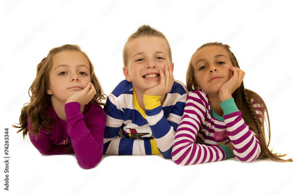 Three children wearing christmas pajamas chin on hands Three children wearing christmas pajamas chin on hands