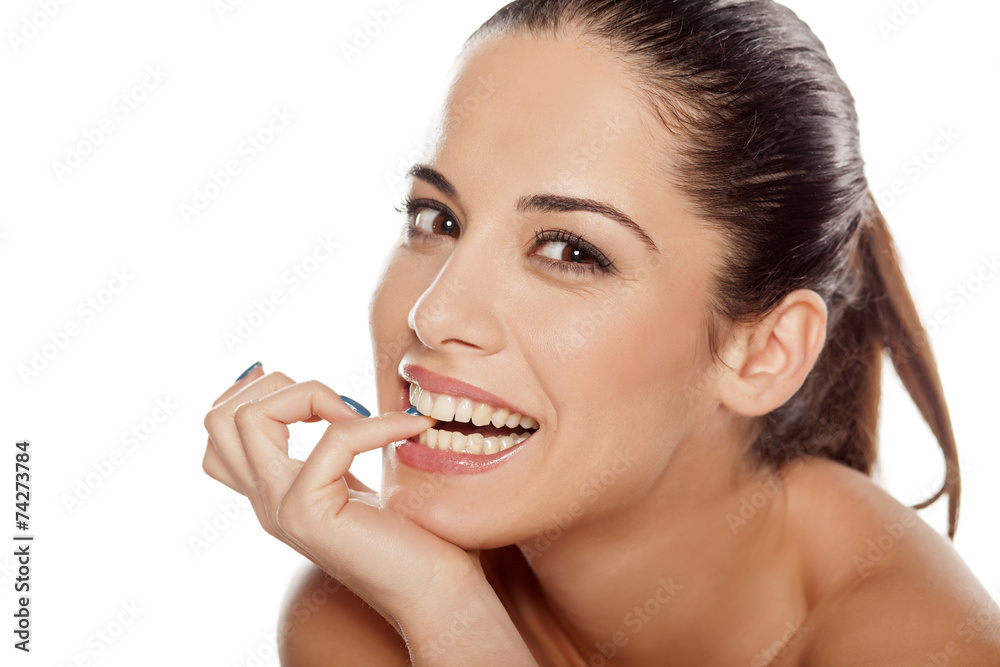 Portrait of beautiful young happy woman nibbling on her finger Portrait of beautiful young happy woman nibbling on her finger