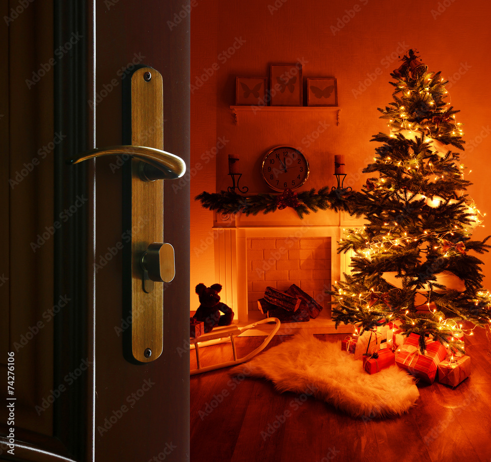 Obraz premium Open door with decorated Christmas tree in room