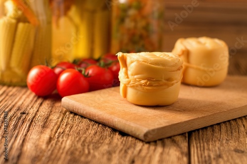 Steamed rolled cheese on wooden board