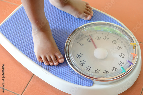 view of scales on a floor and kids feet