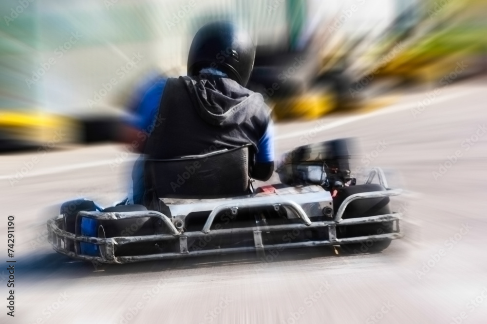 A man is driving Go-kart with speed in the park.