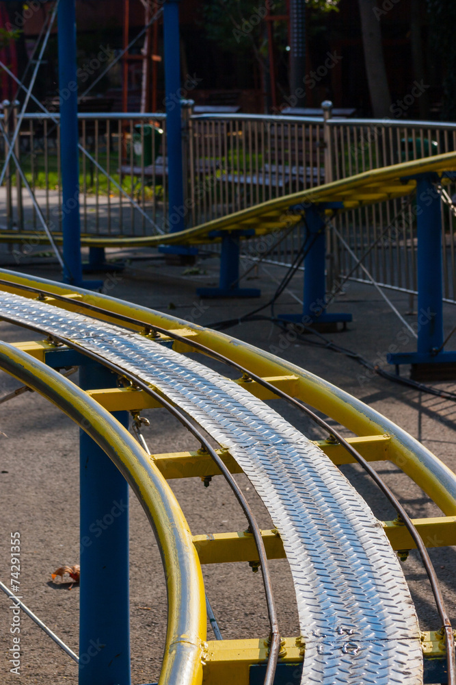 Kids roller coaster yellow rails in amusement park. Kids roller coaster yellow rails in amusement park.