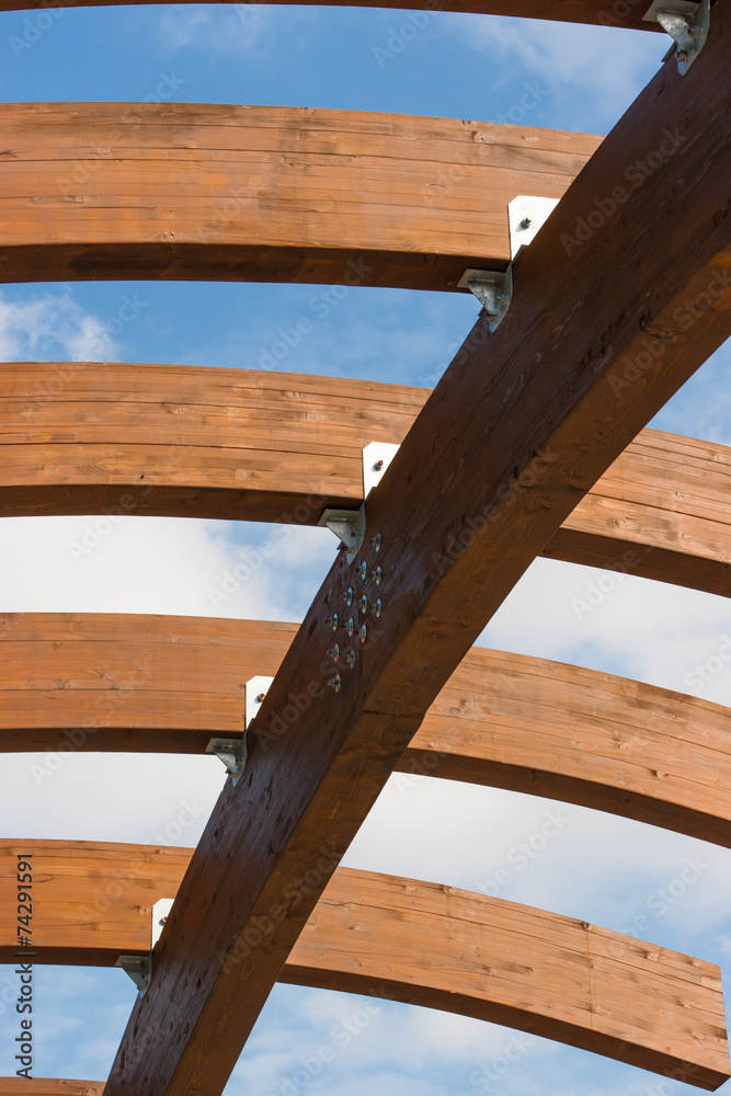 Timber frame arch against blue sky midday underneath view. Timber frame arch against blue sky midday underneath view.