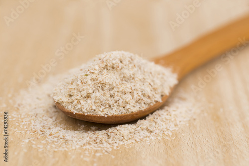 Wooden Spoon with Psyllium Seeds on wooden background