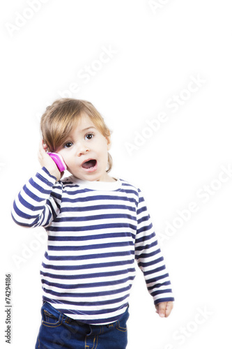 Cute little girl talking with a pink phone isolated on white