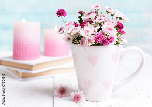 Fototapeta Naklejka Na Ścianę i Meble -  Beautiful flowers in cup on table on light blue background