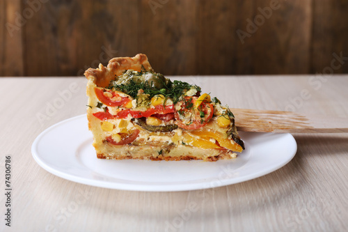 Piece of Vegetable pie with broccoli, peas, tomatoes and cheese