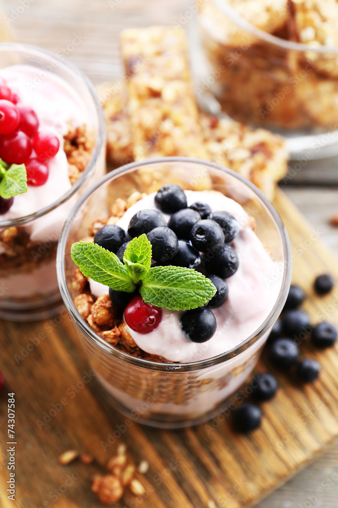 Healthy layered dessert with muesli and berries on table