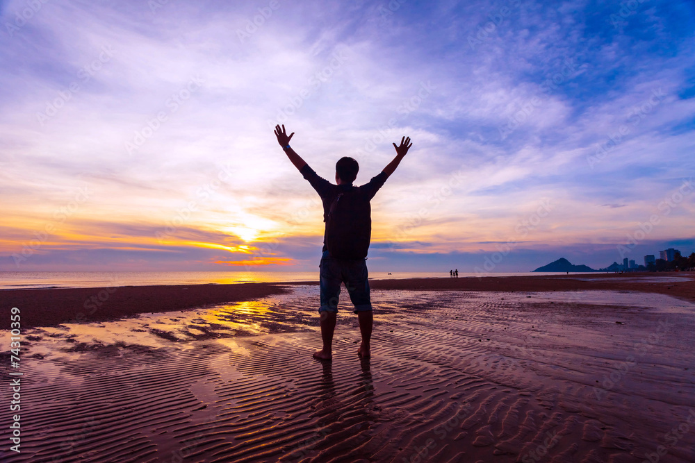 Man Raising His Hands  when sun rising up at sea beach