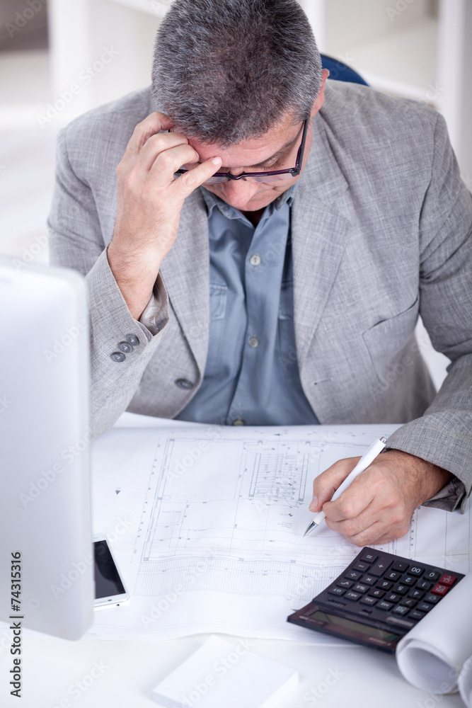 Architect working on construction blueprint in office Architect working on construction blueprint in office