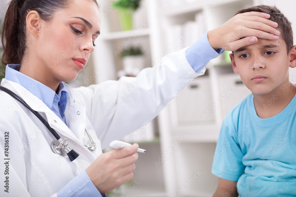 female doctor measuring temperature of boy in clinic female doctor measuring temperature of boy in clinic