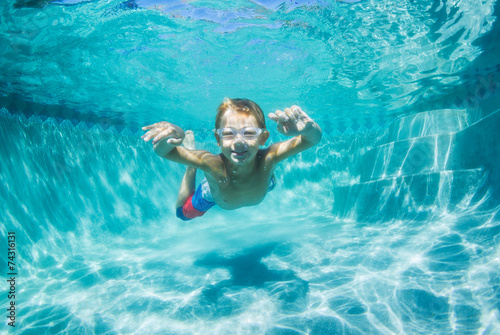 Young Boy Diving Underwater in Swimming Pool