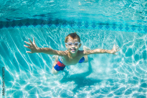 Young Boy Diving Underwater in Swimming Pool