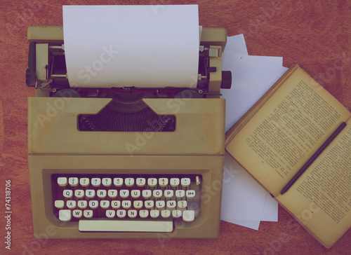 Typing machine, white sheets of paper,old book on a red wooden surface. Top view photo